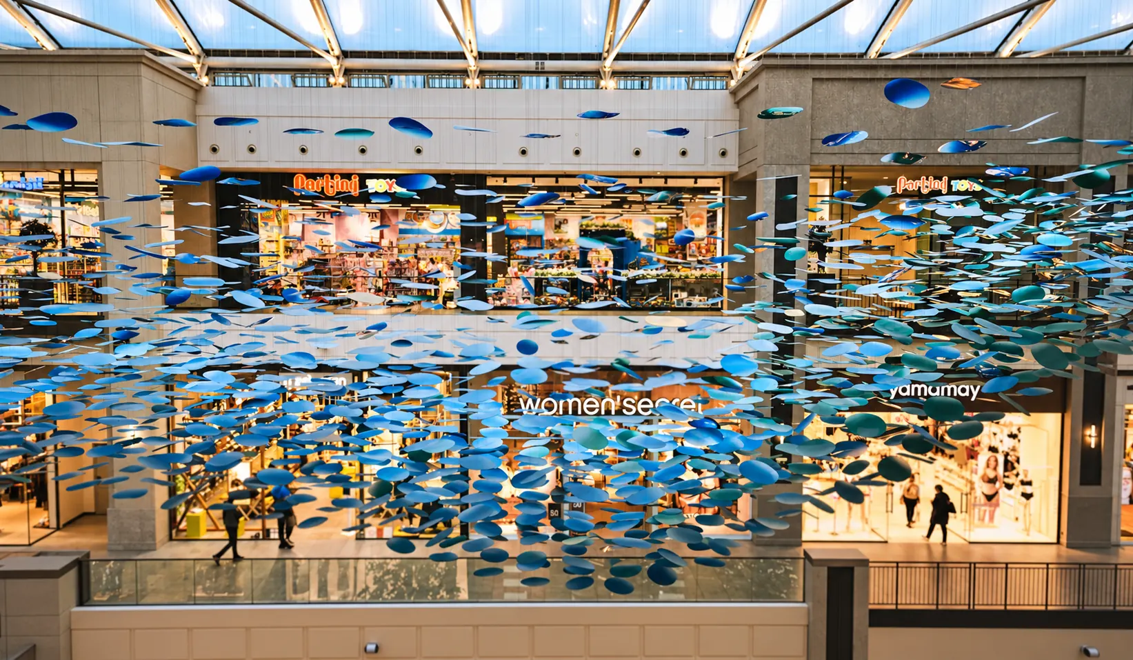 Nuée de pièces bleues suspendue au-dessus de la galerie